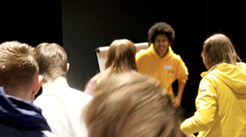 drama and advocacy students wearing colourful clothes dancing in a dark studio