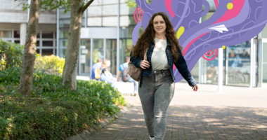 student smiling walking through campus
