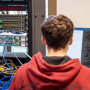 A computing student coding in an IT lab at TUDublin