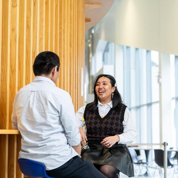 two students sitting on stools