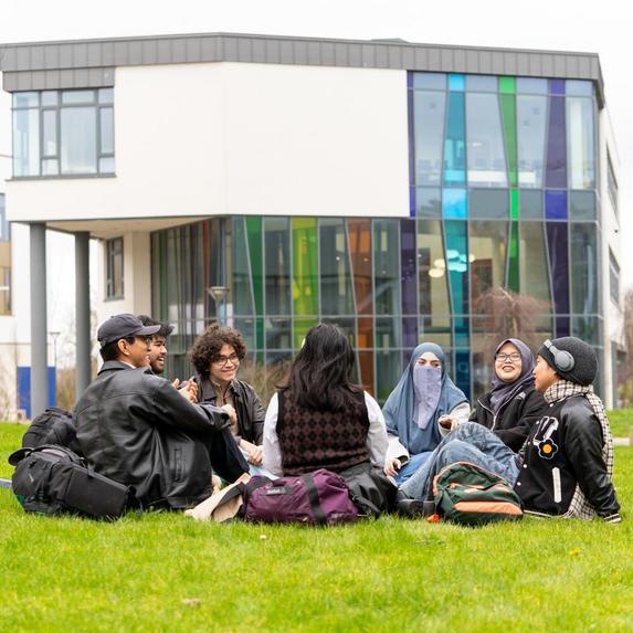 students sitting around grass area