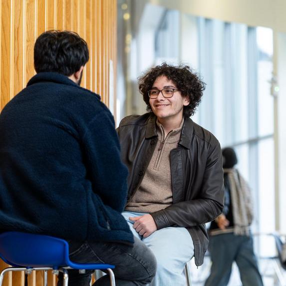 2 Postgrad students sitting on chairs
